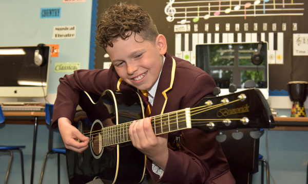 windsor olympus academy student playing the guitar